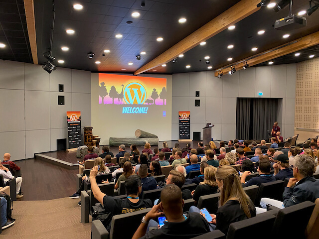 Grote zaal met podium en stoelen vol WordPress-geïnteresseerden op WordCamp NL 2022